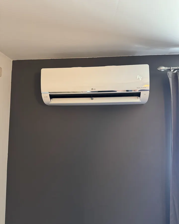 LG airco binnenunit tegen een donkergrijze wand in de slaapkamer