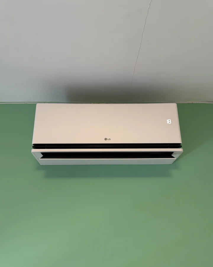 LG binnenunit tegen een groene wand in de derde kamer