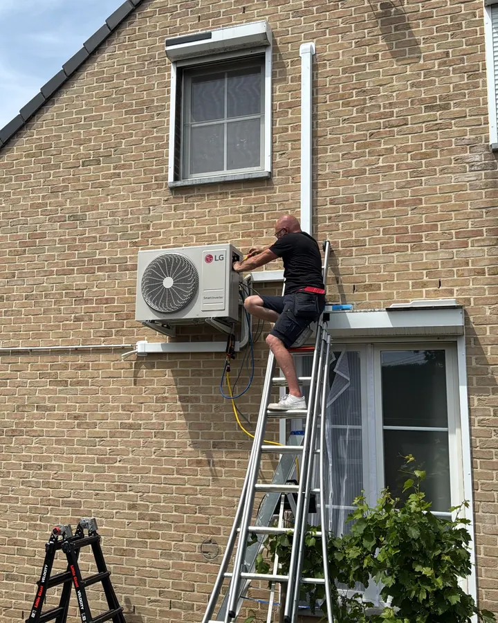 Stephen Van Bael van VB Energy hangt de buitenunit op de wandbeugel