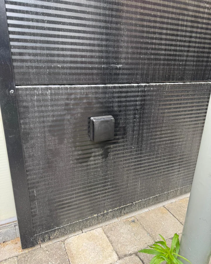 Het buitenstopcontact ingebouwd in de zwarte gevelbekleding