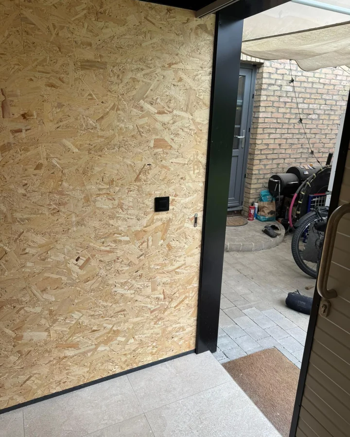 De schakelaar naast de deuropening, op handhoogte