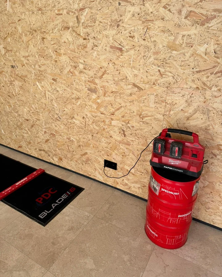 Stopcontact laag aan de wand, hier meteen in gebruik voor de acculader